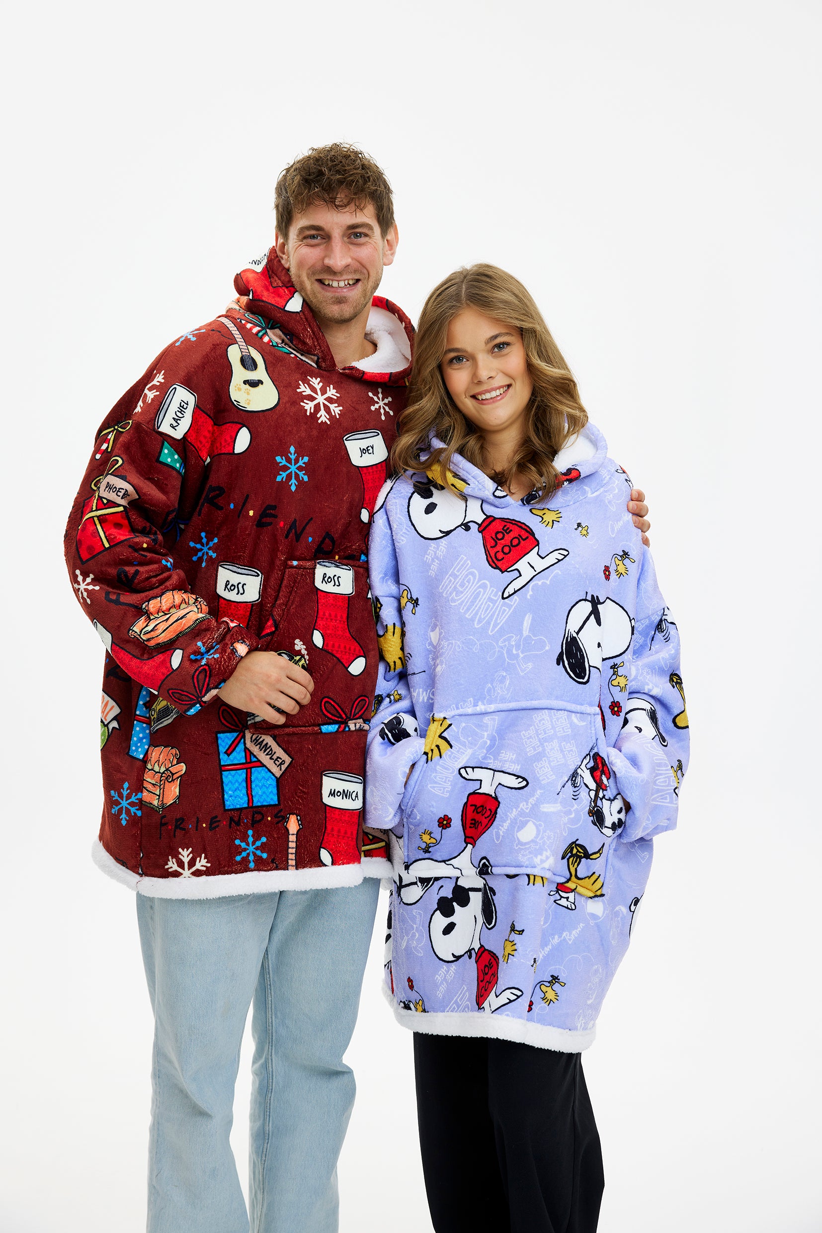 Roter Weihnachtspullover Herren und hellblauer Weihnachtspullover Damen mit Snoopy-Motiven, beide als Weihnachtspyjama.